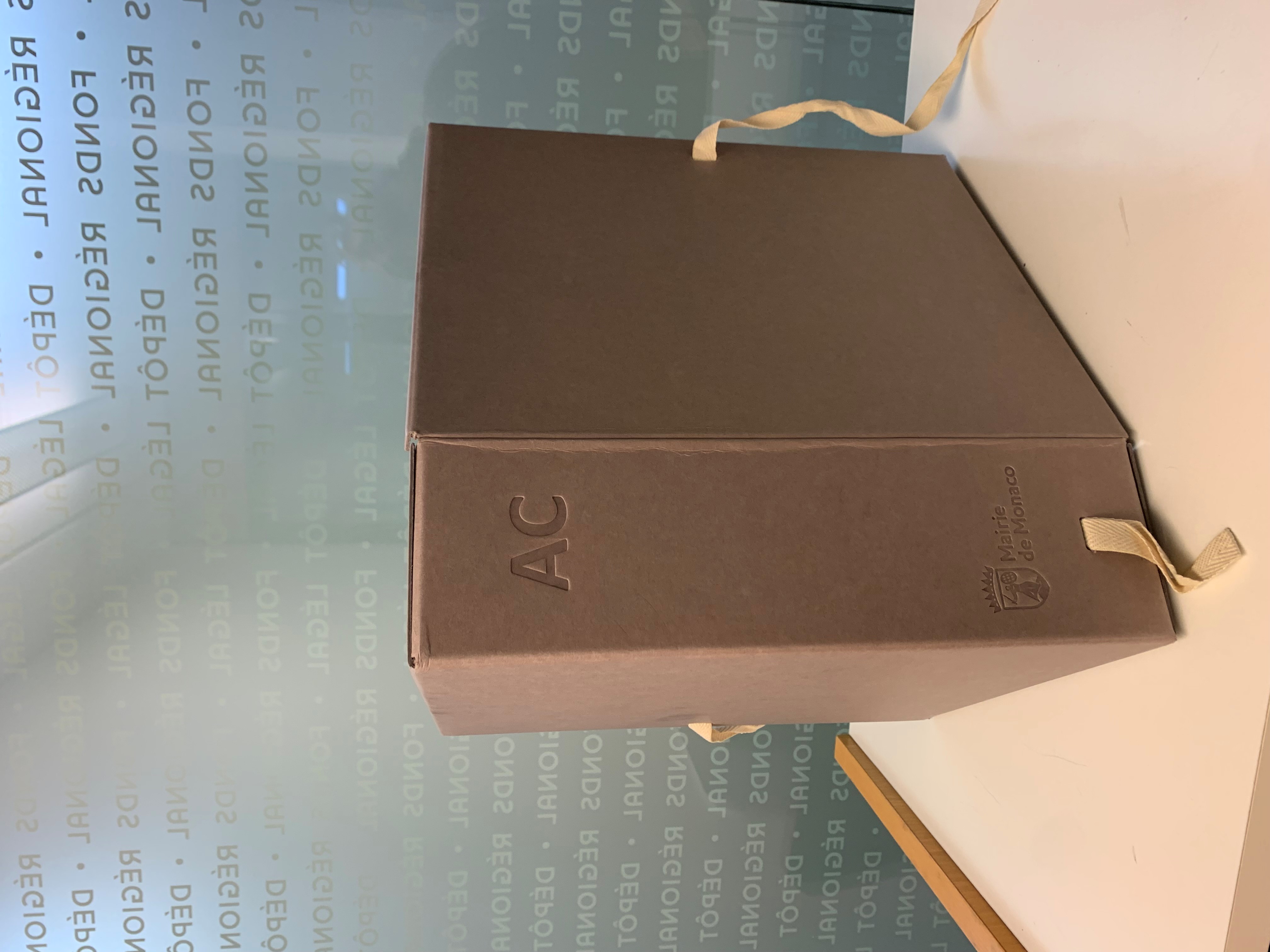 Boîtes de conservation des archives communales de Monaco, estampillées du logo de la mairie 